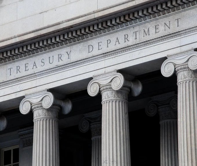 A photograph of the facade of the U.S. Treasury Department building, showing large Ionic stone columns and the engraved text 'TREASURY DEPARTMENT' above the entrance.