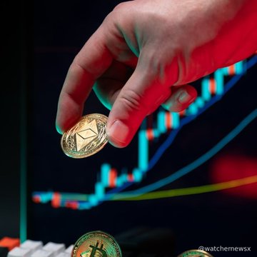A hand holds a gold-colored cryptocurrency coin (resembling Ethereum) in front of a digital display showing a green upward-trending candlestick chart, with the watermark '@watcher_guru'.