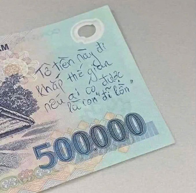 A Vietnamese 5,000,000 dong banknote has handwritten text in Vietnamese that translates to a romantic message: 'T8 Tien nay di khap the gian neu ai co duoc la con di loan'.