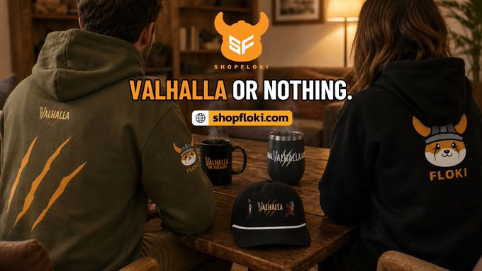 The image shows two people from behind wearing branded merchandise—an olive green hoodie with "Valhalla" and claw marks, and a black hoodie featuring a Shiba Inu graphic with "Floki"—sitting at a table displaying matching "Valhalla" mugs and a cap. Bold text overlays read "VALHALLA OR NOTHING" with the ShopFloki logo and "shopfloki.com," promoting the official Floki Valhalla merch collection referenced in the post.