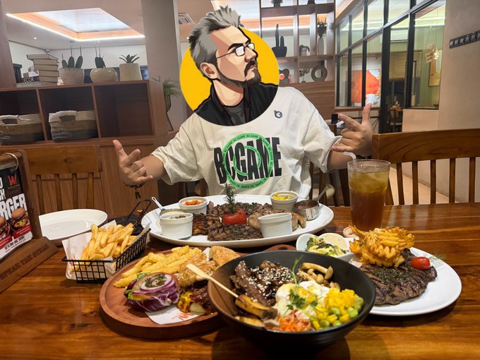 The image features a man sitting at a dining table with plates of food, including a bowl of carrots, a plate of meat, and other dishes such as fries and a sandwich. The man has his arms outstretched, giving off a playful vibe. In the background, there is a bookcase filled with books, suggesting that this might be a restaurant or cafe where people can enjoy their meals while reading or engaging in conversation. The post about the meal also mentions that it's time for late-night snacks and that the food is still sponsored by @bcgame.