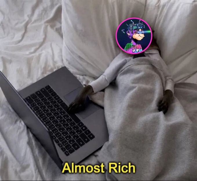 A humorous meme image of a monkey-like figure with a colorful profile picture avatar sitting in bed with a laptop, captioned 'Almost Rich' in yellow text.