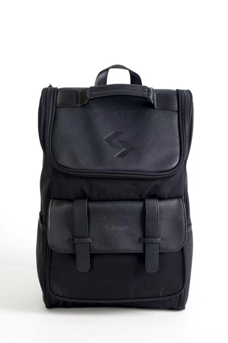 A black fabric backpack with a top flap, front buckle pockets, and a stylized 'S' logo, with 'Seleco' text visible on the lower front flap.