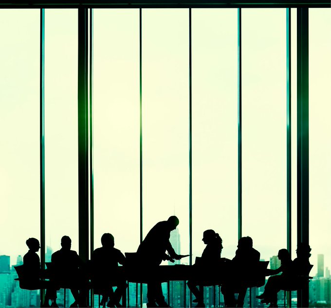 Silhouettes of officials gather around a conference table against floor-to-ceiling windows overlooking the London skyline, symbolizing the high-level US-UK Financial Regulatory Working Group meeting that addressed stablecoin and payments coordination between the Treasury, Fed, SEC, and Bank of England.