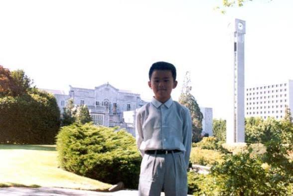 The image features a young boy standing outside of a building with a clock tower behind him. The boy appears to be posing for a photo, possibly at a park or an event. In the background, there are trees that add a natural element to the scene. The caption above the image reads "Be @cz_binance Born in rural China with no running water Flee to Canada to escape political unrest Flip burgers at McDonald's for $5 an hour Develop a crazy, unbreakable work ethic A friend". This message seems to be related to the boy posing for the photo and possibly his life story.