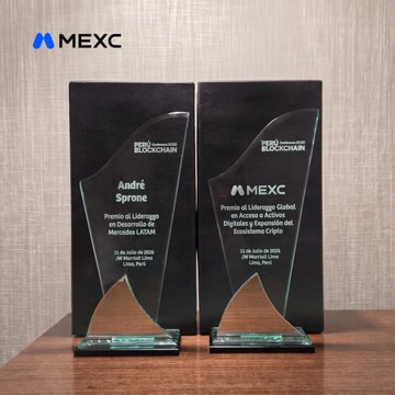 Two glass awards from the "Premios Blockchain" sit on a wooden table, one recognizing MEXC as a "Premio de Liderazgo Global en Accesibilidad" and the other honoring "André Sprone" with a "Premio al Liderazgo en el Desarrollo de Mercados LATAM," both dated July 11, 2025, in Lima, Peru—celebrating MEXC's recognition and commitment to the LATAM crypto community as teased in the post.