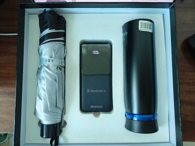 An unboxed product set containing a black umbrella branded "太空甲" (Space Armor), a "Newmine" branded device, and a black cylindrical flashlight/accessory in foam packaging.