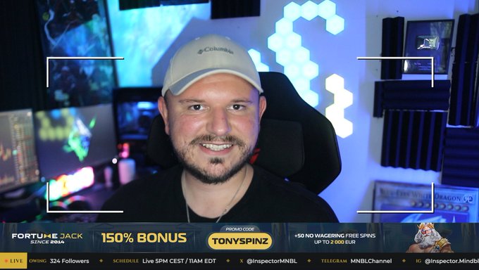 A man wearing a Columbia cap smiles in a streaming setup with neon lighting, with a 'FORTUNEJACK SINCE 2014' banner showing '150% BONUS' promo code 'TONYSPINZ' and 50 no wager free spins.