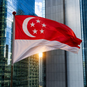The Singapore flag waves prominently against a backdrop of modern skyscrapers, symbolizing Southeast Asia's growing prominence as a fintech and crypto hub following news that the region saw $680 million in crypto funding for 2026, largely driven by Crypto.com's $400 million raise.