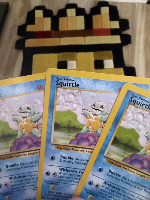 Three well-worn, decades-old "Squirtle" Basic Pokémon cards are fanned out in front of a pixelated 8-bit castle rug, visually backing the poster's claim of "diamond hands" by showcasing cards from the original 1990s Pokémon TCG that have been held onto for roughly 30 years.