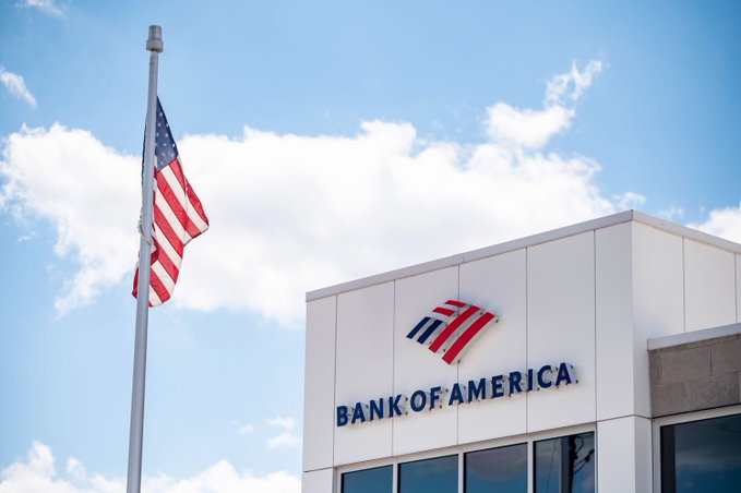 The image features a white building with an American flag flying above its roof, indicating that the bank operates within the United States. The text "Bank of America" is displayed prominently on the building's facade, suggesting that this is the bank's name or logo. The presence of the American flag and the bank's name together convey a sense of patriotism and pride in one's country.