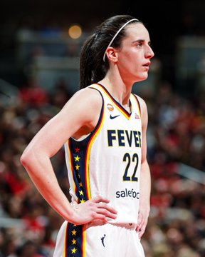 A Indiana Fever player wearing jersey #22 (Caitlin Clark) stands on the court during a WNBA game, looking off to the side with a focused expression. The image relates to the post by showcasing the Fever team whose dramatic buzzer-beater victory led to a substantial $416,681.76 payout, prompting celebratory reactions.