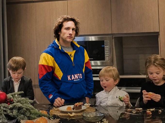 The image shows a man wearing a blue and yellow jacket standing next to his children who are eating food off of a table. The family appears to be enjoying their time together, with the father possibly discussing something related to cryptocurrency or investing with his kids. In the background, there is an oven visible in the kitchen area, indicating that they might have been cooking or preparing a meal before sitting down for dinner.

The post includes text about selling Ethereum and how it has increased in value over time, which could be related to the father's discussion with his children. The post also mentions Pokemon cards as a possible reason for the father's decision to invest in cryptocurrency.