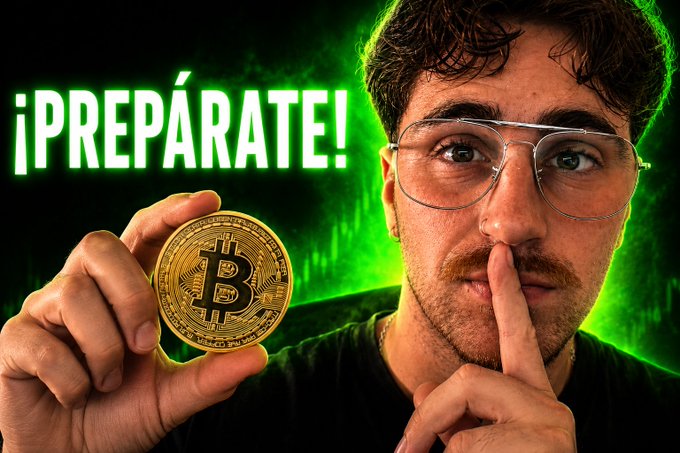 A thumbnail-style image featuring a man with glasses holding his finger to his lips in a 'shh' gesture while displaying a Bitcoin coin, with the Spanish text '¡PREPÁRATE!' in glowing green letters.