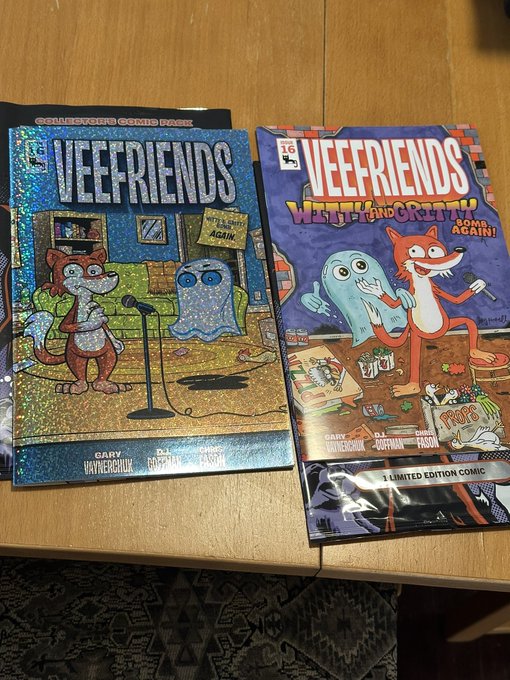 Two 'Veefriends' comic books on a wooden table - one titled 'I Tried to Warn You Again' (Collector's Foil Foil) and another 'Went Up and Came Down Again!' (Limited Edition Comic), both by Gary Vaynerchuk.