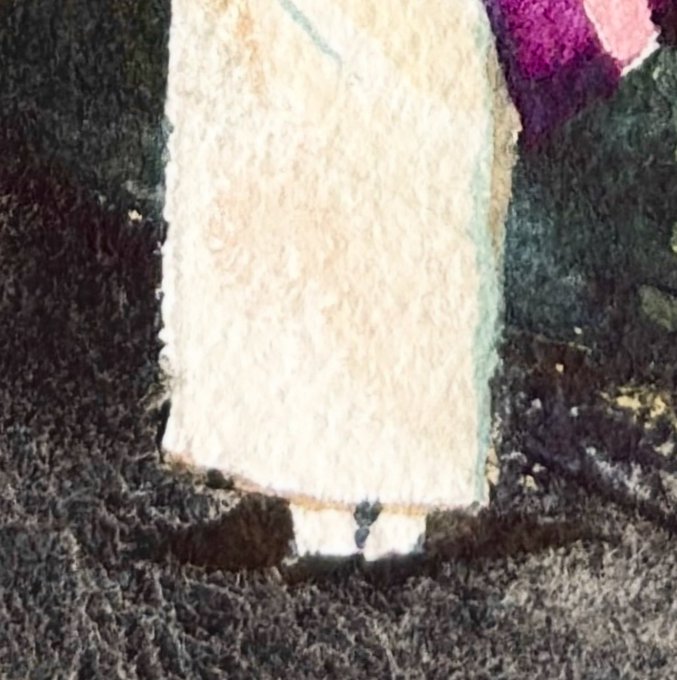 A blurry, dark, and abstract image showing what appears to be fabric with a cream-colored panel in the center.