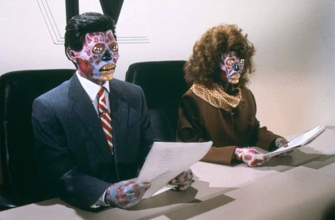 A vintage photograph of two people in business attire sitting at a desk reading papers, with their faces painted/transformed into skull-like monster designs.