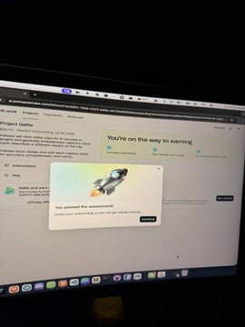 A computer monitor displays a webpage with a rocket illustration and a popup message reading 'You passed the assessment,' congratulating the user on completing some kind of test or survey.