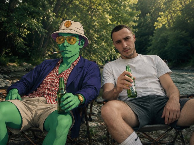 A photo showing a person with green skin, a purple blazer, and bucket hat sitting next to another person, both holding beer bottles.