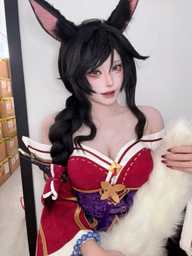 A cosplayer poses at CollectibleCon dressed as Rosentica from the Riftbound Arena TCG, featuring the character's signature black bunny ears, dark hair, and an ornate red, white, and gold corset outfit.