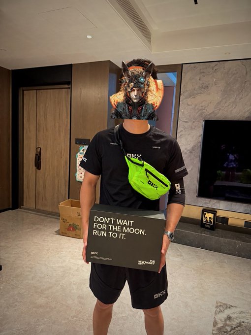 A person wearing an elaborate horned mask and OKX-branded apparel holds a black box reading "DON'T WAIT FOR THE MOON, RUN TO IT." alongside OKX branding, celebrating their $100,000 USD lottery win at the first-ever OKX New Year's Eve dinner.