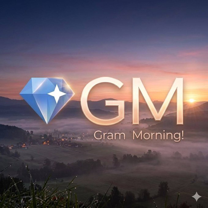 The image features a beautiful sunrise over a valley with mountains, creating a serene and picturesque scene. In the center of the image, there's an advertisement for GM $GRAM MORNING that includes a blue diamond logo and the text "GM $GRAM MORNING!". The background of the image is filled with foggy mountains, adding to the overall atmosphere of the post.