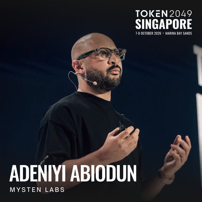 The image features Adeniyi Abiodun, Co-Founder and CPO of Mysten Labs, speaking on stage with a headset microphone at TOKEN2049 Singapore (7-8 October 2026, Marina Bay Sands). The promotional graphic aligns with the post's announcement of his return to the event, where he advocates for full-stack ownership beneath L1 blockchains like Sui Network.