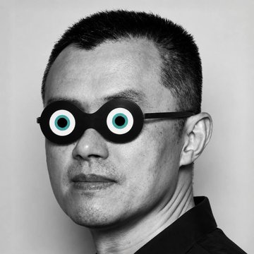 A black and white portrait of a man with short hair wearing round novelty glasses with cartoon eyes.