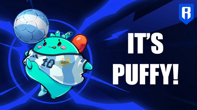 A teal axolotl-like character named "Puffy" from Axie Infinity wears a white jersey with the number "10" and a small gold crown logo, balancing a soccer ball on its head. Bold white text on the right reads "IT'S PUFFY!" against a dynamic blue splatter background with an "R" logo in the corner.