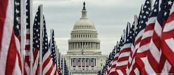 The image features a large group of American flags arranged in front of the United States Capitol building. The flags are spread out, creating a sense of unity and patriotism. The caption above the image reads "CLARITY IS COMING Tim Scott is backing Trump's push to make America the crypto capital of the world. The CLARITY Act brings regulatory certainty, protects consumers, and keeps innovation in the U.S." This suggests that there might be discussions or debates about cryptocurrency regulations in the United States, possibly related to the Capitol building.