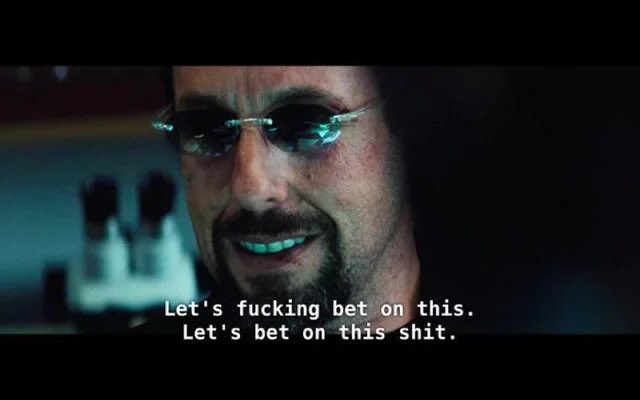 The image features a scene from the movie "Let's Kill Bill", where a man in sunglasses is talking into a microphone or speaking through a headset while holding a cell phone, possibly texting or browsing. The text displayed above him says "let's f*ck this," suggesting an aggressive or confrontational tone. This phrase can be related to the Bitcoin post that mentions $65,000 being claimed for Bitcoins following the US announcing a peace deal with Iran.