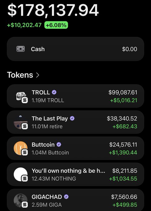 The main focus of this image is a screenshot from a smartphone, showcasing a list of cryptocurrencies with their values displayed against the black background. Among these items, there are three prominent ones - "TROLL", "Buttermilk" (also known as "FUT", but it seems to be an abbreviation for "futures"), and "buttermilk". The prices are clearly visible, ranging from $3,543.23 to a total of $1,000,039.76. In the bottom right corner of the image, there is a small amount of text that reads "You'll own nothing & be h...", which is unrelated and possibly a comment or an explanation about the cryptocurrency list.