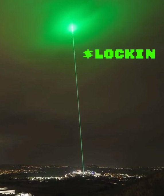 A nighttime cityscape with a bright green laser beam shooting into the sky, accompanied by pixelated green text reading '*LOCKIN'.