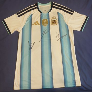 An Argentina national football team Adidas jersey in light blue and white stripes with three stars, featuring handwritten signatures on the front.