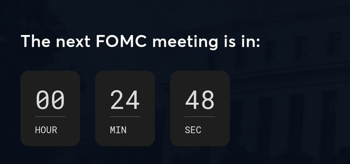 A countdown timer displays 'The next FOMC meeting is in:' with 00 hours, 24 minutes, and 48 seconds remaining against a dark background of a building.