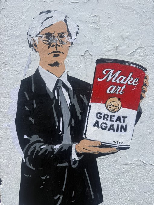 Street art stenciled on a wall depicting an older man in a suit holding a soup can labeled "Make art GREAT AGAIN" with the artist's tag "TVBOY".