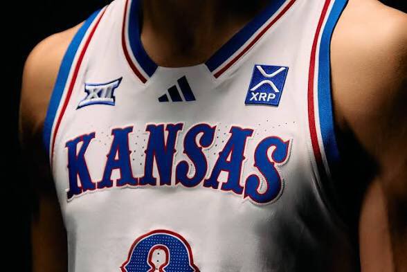 A close-up of a basketball player wearing a white 'KANSAS' jersey with Big 12 (XII), Adidas, and XRP logos.