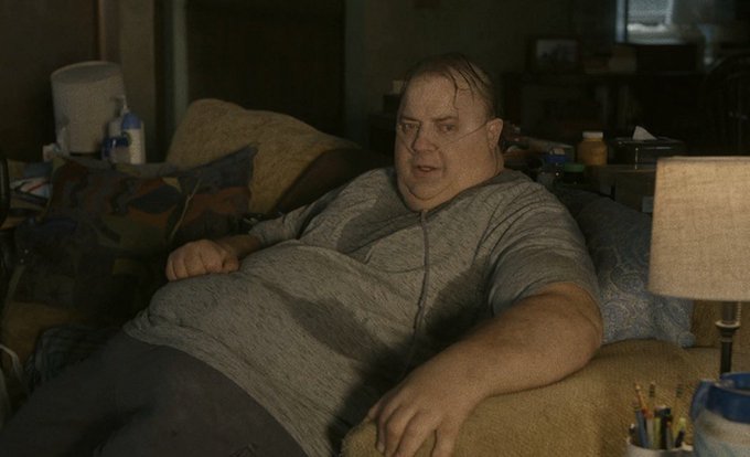 A heavy-set man wearing a nasal cannula and a gray t-shirt lounges on a couch cluttered with pillows, surrounded by medicine bottles, a lamp, and art supplies. The scene fits the post's chaotic humor about "devouring" tokens, with the man appearing lethargic and surrounded by the messy remnants of an indulgent lifestyle.