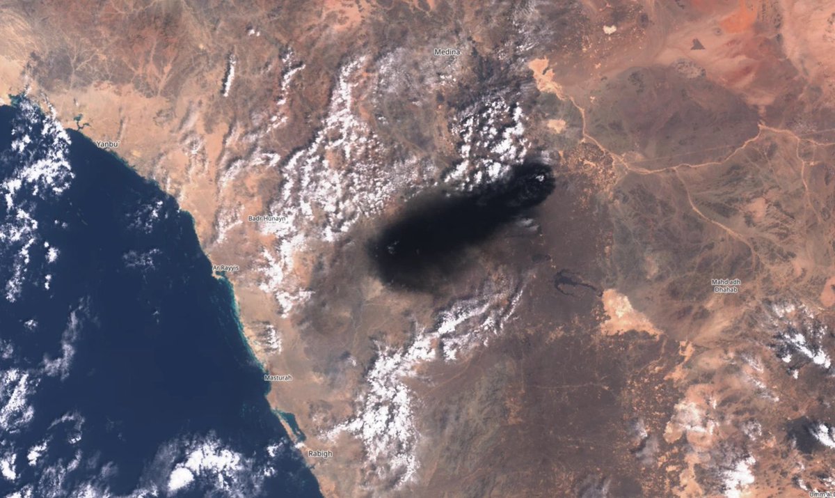 A satellite image shows a large dark smoke plume drifting westward from the area between Medina and Mahd adh Dhahab in Saudi Arabia, with coastal cities Yanbu, Badr Hunayn, Ar Rayyis, Masturah, and Rabigh labeled along the Red Sea. The plume visually corresponds to the reported Houthi ballistic missile strike on Saudi Arabia's East-West oil pipeline that caused multiple fires, including one near a pumping station.