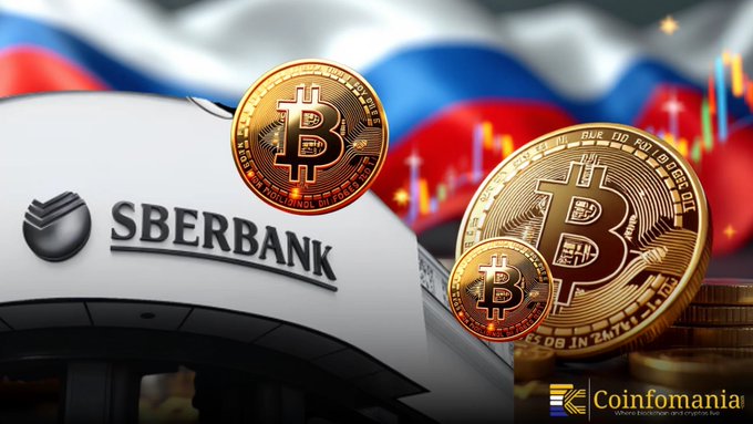 The image features the Sberbank logo displayed on a building with the Russian flag in the background, overlaid with prominent gold Bitcoin coins and a cryptocurrency trading chart, visually reinforcing the post's message about Sberbank's growing involvement in integrating crypto assets into traditional banking.
