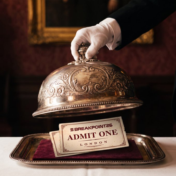 An elegant photograph of a gloved hand lifting an ornate silver cloche/dome to reveal a vintage-style ticket reading 'SBREAKPOINT26 ADMIT ONE LONDON' resting on a burgundy velvet-lined silver tray.