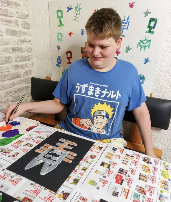A young boy wearing a blue Naruto Uzumaki t-shirt paints a character on black paper, with a backdrop featuring colorful pixelated TV and antenna designs, seemingly illustrating his interest in NFTs and digital art that ties into the post's mention of collecting fees with @NFTLove_eth.