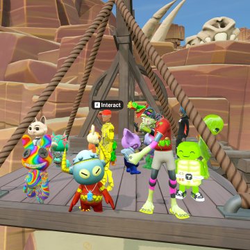 A group of vibrant, colorful cartoon-style avatars gather on a wooden platform with a large skull rock and dinosaur bones visible in the background, while one character displays an "Interact" prompt above its head. The scene reflects a social metaverse gathering, likely connected to the "First Deed" virtual world mentioned by @tropicalvirtual in the accompanying post.