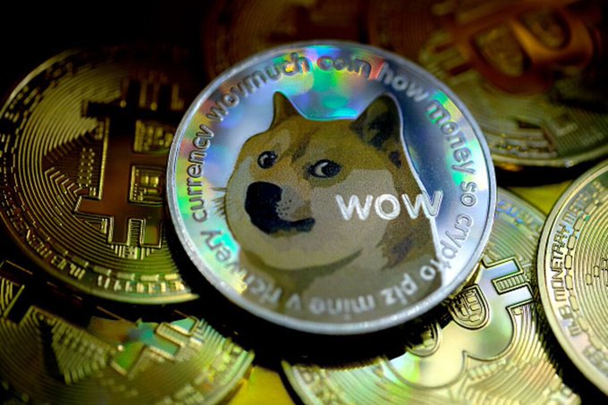 Close-up of a Dogecoin cryptocurrency token featuring the Shiba Inu dog and the word 'wow', resting on top of several gold Bitcoin coins.