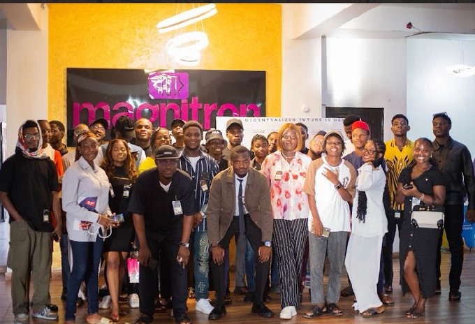 A group of attendees poses for a photo at a Magnittros event, with the brand's pink logo and "DECENTRALIZED FUTURE TOGETHER" tagline visible on the backdrop. The gathering appears to be a professional networking or startup-focused meetup that aligns with the celebratory post congratulating @NERO_bx on their achievements within the XRP Ledger (XRPL) community.