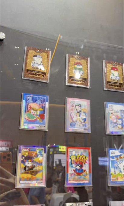 Display of collectible trading cards, including "NAKAHOCHI" and "PUSSY" themed cards featuring cartoon characters.