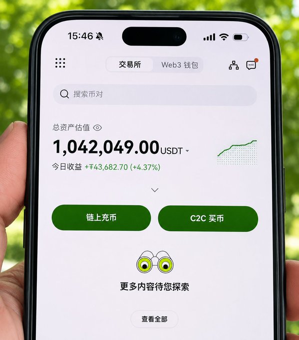 The image shows a person holding a cell phone with a green screen displaying a financial app that has a cartoon character with big eyes and a small head. The app's interface features two buttons labeled "CZC" and "1,042,939.00USDT". The person is holding the phone in front of them, possibly showing off or explaining something related to the app displayed on the screen.
