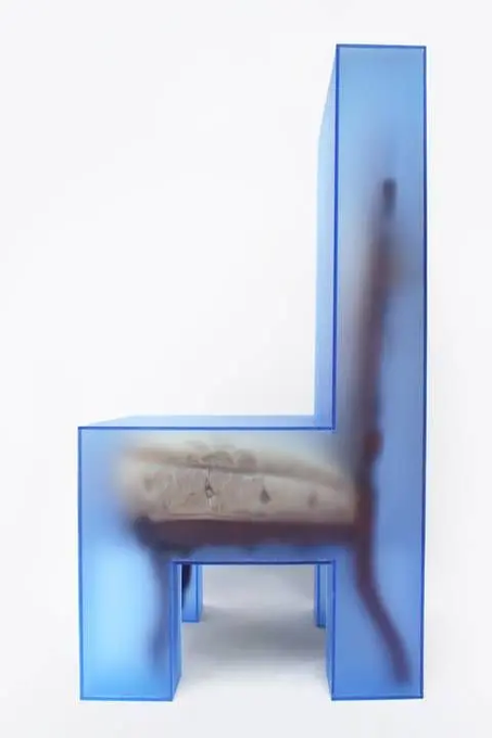 A translucent blue resin chair contains a preserved small alligator inside its seat.