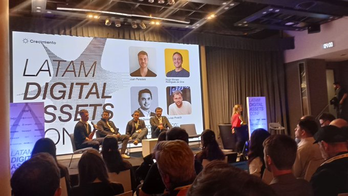 A panel discussion at the 'LATAM DIGITAL ASSETS' conference hosted by Crecimiento, featuring speakers including Juan Pablo and Nigel Hemsani.