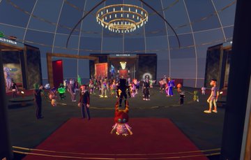 A screenshot of a virtual reality gathering in a domed venue, where numerous avatars stand on a red carpet under a large chandelier.